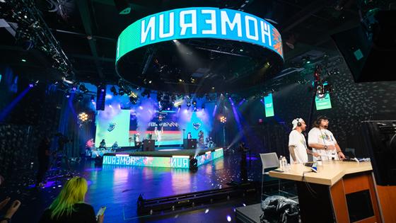 A wide shot of Full Sail’s esports arena during the Sunburst Classic with the words “home run” in large block lettering on an LED screen.